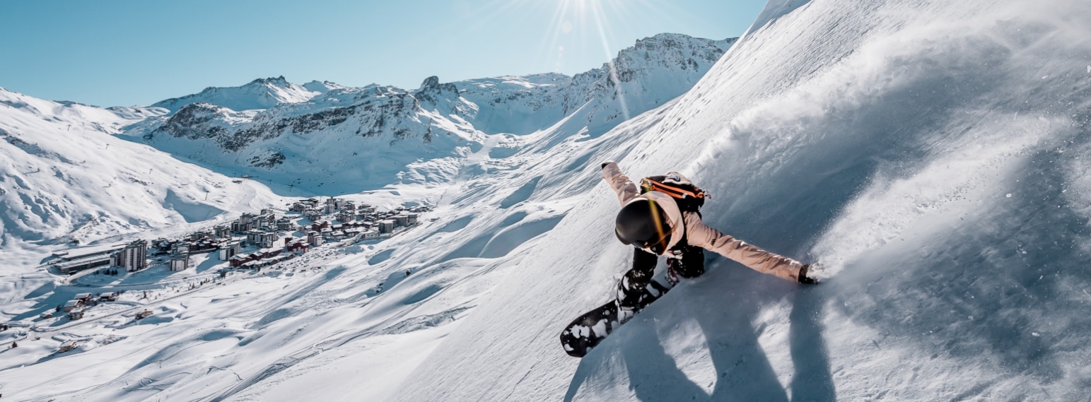 Snowboarder on high steep slope above Tignes 2100 in the French Alps